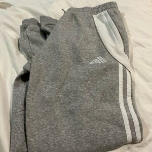 Adidas Gray Joggers with White Stripes and zip pickets. Adult XS